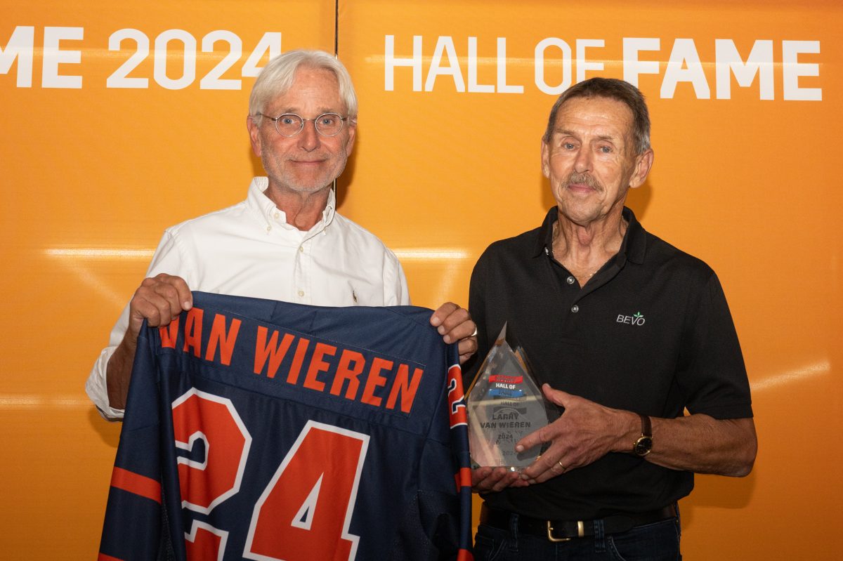 Larry van Wieren (rechts) neemt de Hockey Hall of Fame bokaal en - shirt in ontvangst van verkiezingscommissielid Jan Janssen