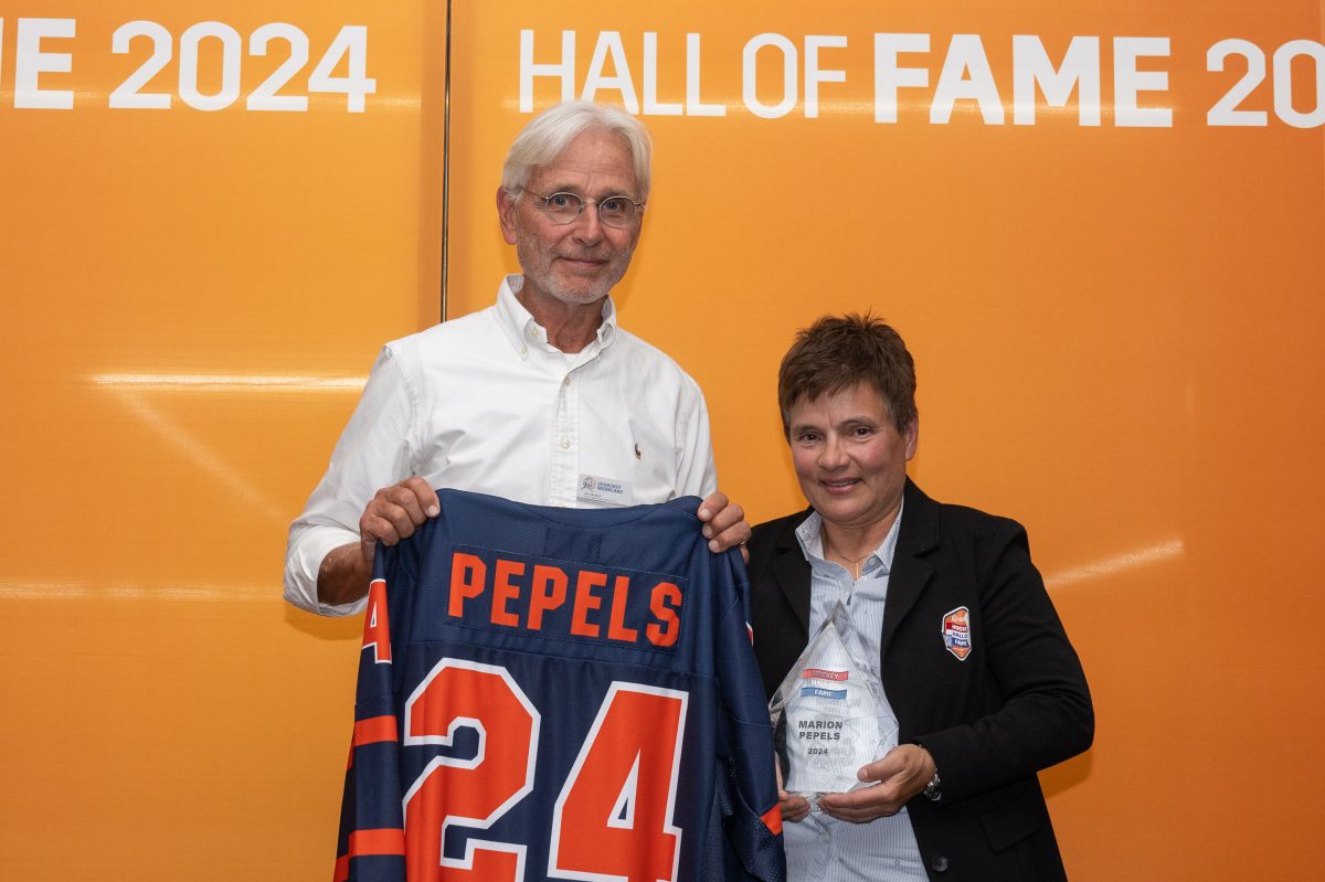 Marion Pepels neemt de Hockey Hall of Fame bokaal en - shirt in ontvangst van verkiezingscommissielid Jan Janssen