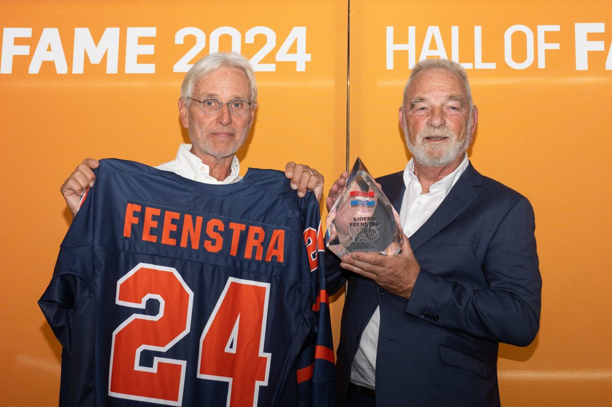 Fred Frehé (rechts) neemt, namens Sjoerd Feenstra, de bokaal en shirt in ontvangst behorende bij het lidmaatschap van de Hockey Hall of Fame uit handen van verkiezingscommissielid Jan Janssen