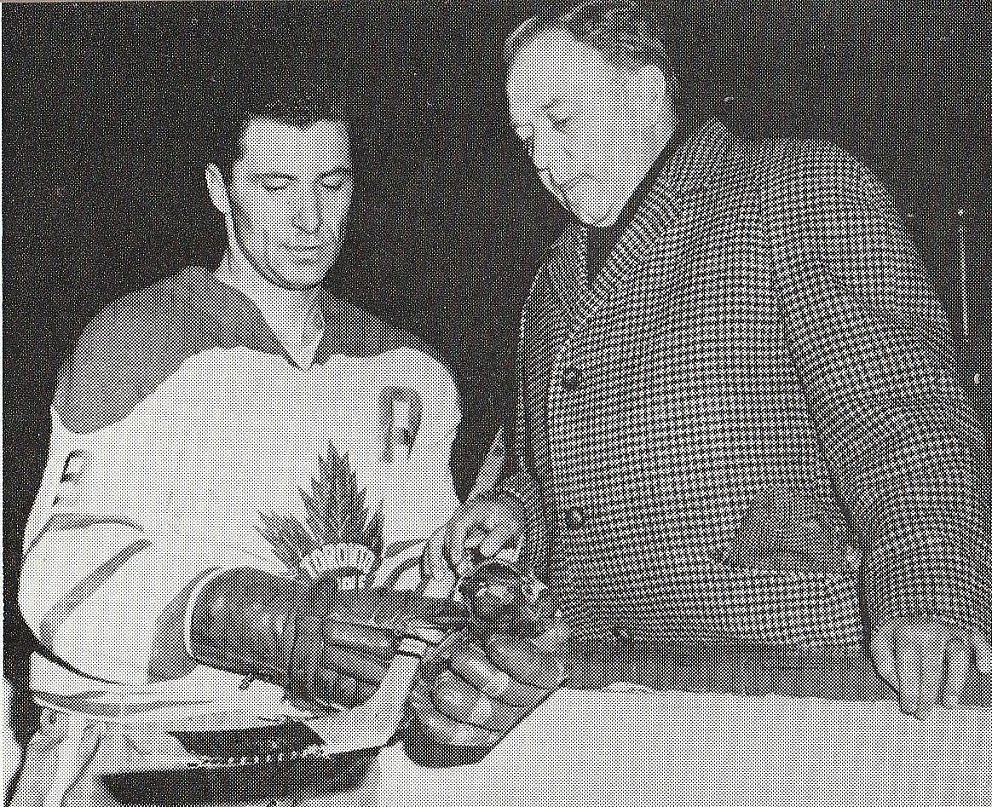 NHL coryfee Andy Bathgate toont Frans Henrichs een noviteit; een gebogen stick (1965)