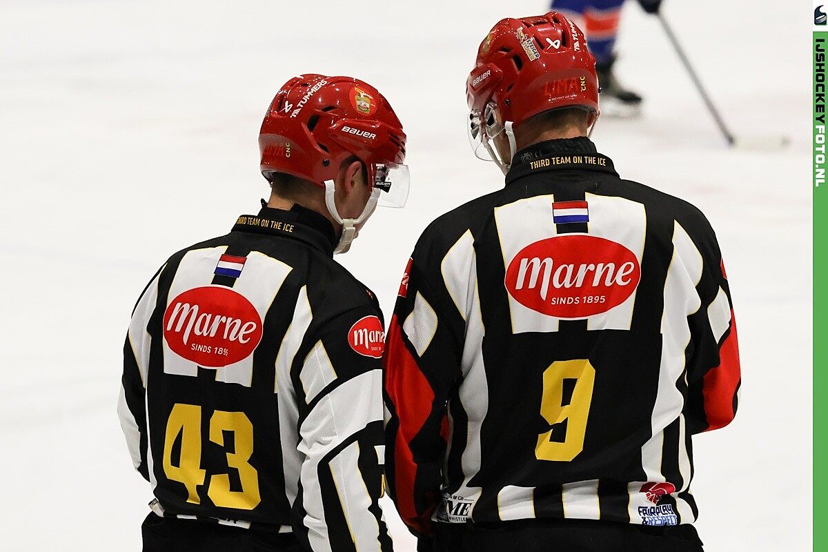 2 scheidsrechters in overleg bij een ijshockey wedstrijd