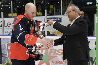 Voorzitter Danny Micola van IJshockey Nederland reikt de kampioensbeker uit aan Nijmegen-captain Derek Knetter