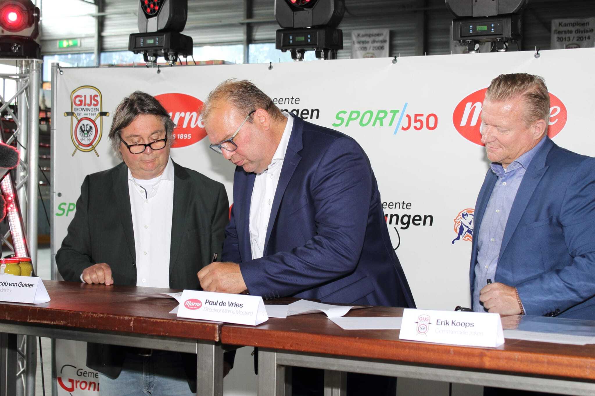 Directeur Paul de Vries tekent het contract met Gijs Marne Groningen onder toeziend oog van Jacob van Gelder en Erik Koops